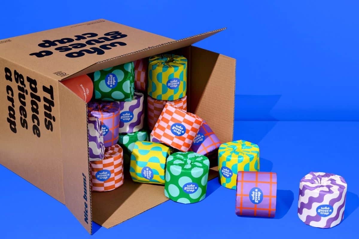Who Gives a Crap bamboo toilet rolls in a “This place gives a crap” cardboard box, each wrapped in bright patterned paper.